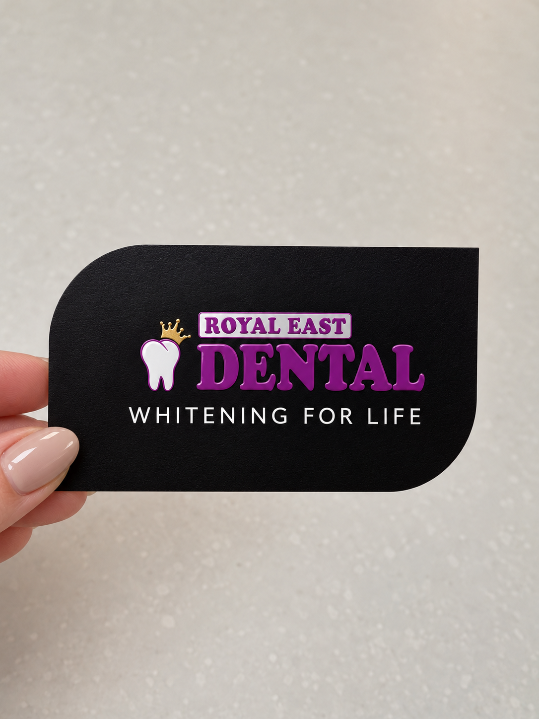Royal East Dental business card held in hand